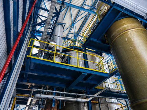 Spray roaster plant with steel structures, pipes and yellow safety railings
